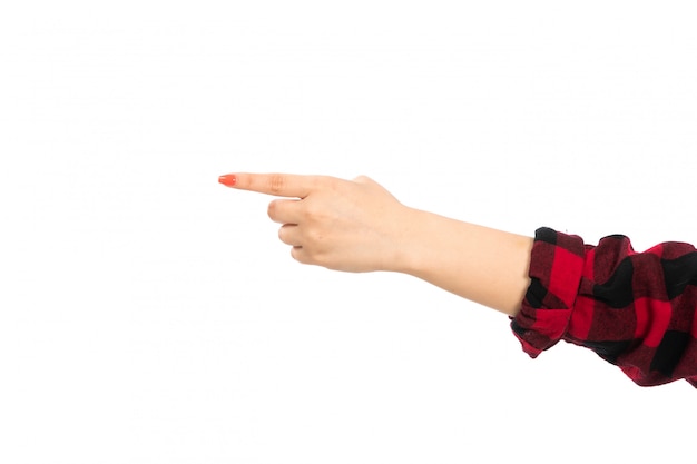 Una vista frontal mano femenina en camisa a cuadros negro-rojo señalando el camino en el blanco