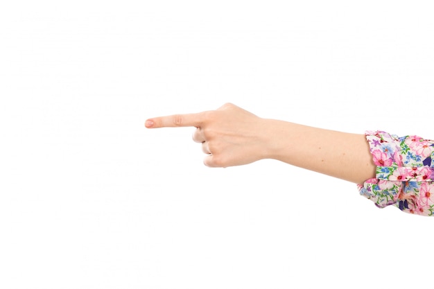 Una vista frontal mano femenina que muestra el dedo señalando el signo en el blanco