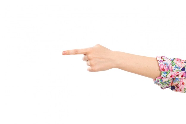 Una vista frontal mano femenina que muestra el dedo señalando el signo en el blanco