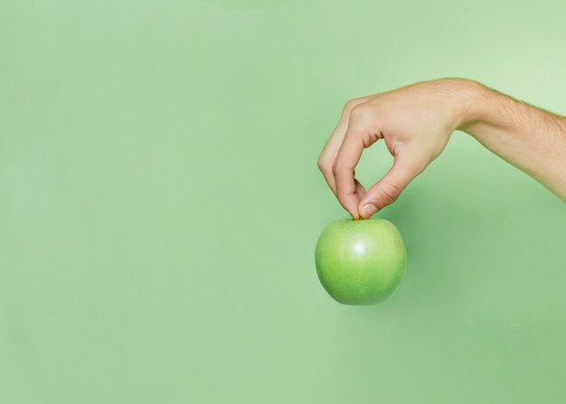 Vista frontal de la mano que sostiene la manzana