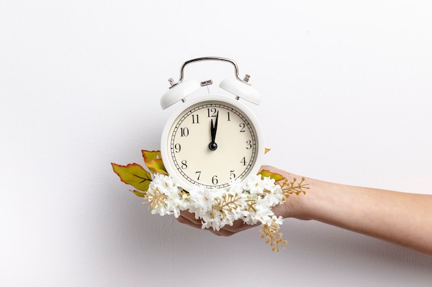 Vista frontal de la mano que sostiene el reloj con flores