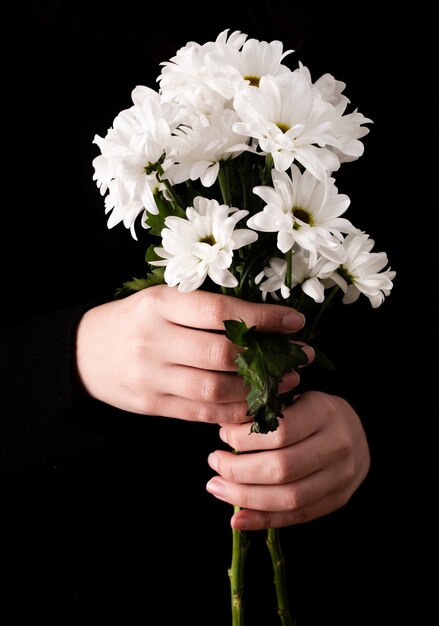 Vista frontal manos con flores de primavera