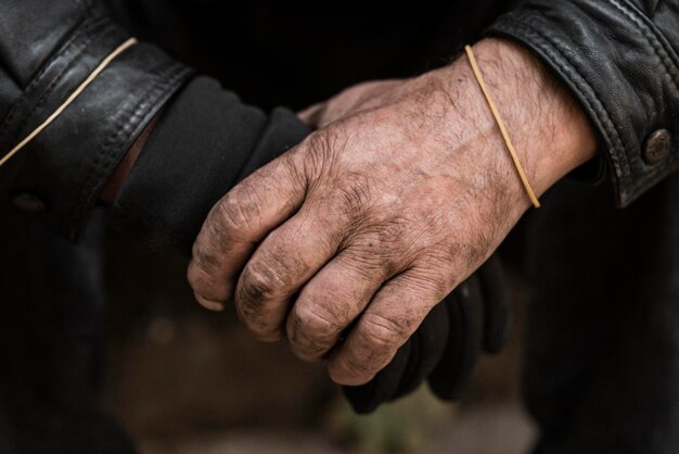 Vista frontal de las manos de la persona sin hogar
