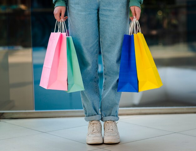 Vista frontal manos sosteniendo bolsas de compras