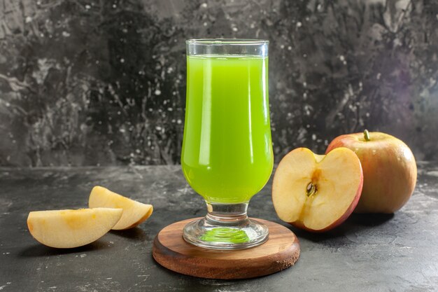 Vista frontal de la manzana madura fresca con jugo de manzana verde en el color de la foto del árbol de jugo suave oscuro