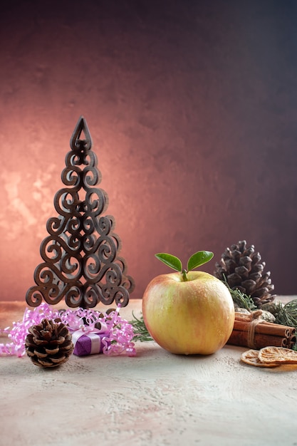 Vista frontal manzana madura fresca con juguetes y arbolito de navidad en color de foto de arbol de jugo suave claro