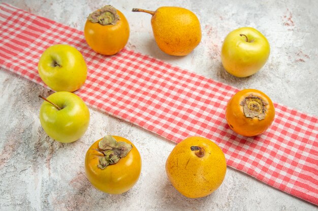 Vista frontal de las manzanas frescas con caquis en la salud de la baya de la fruta de mesa blanca