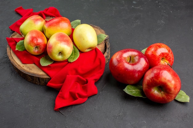 Vista frontal de manzanas frescas frutas maduras en tejido rojo y mesa gris fruta madura de árbol fresco