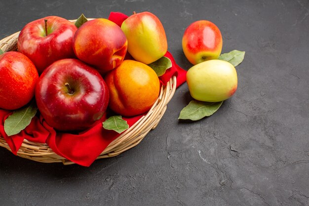 Vista frontal de manzanas frescas con melocotones en la mesa oscura jugo suave de árbol de frutas maduras