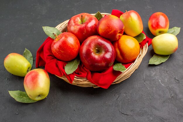 Vista frontal de manzanas frescas con melocotones en una mesa oscura jugo suave de árboles frutales maduros