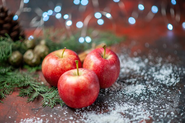 Vista frontal manzanas rojas canela en polvo de coco sobre fondo rojo aislado