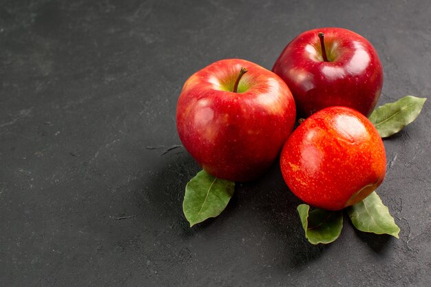 Vista frontal manzanas rojas frescas frutas suaves en la mesa oscura fruta roja árbol maduro fresco