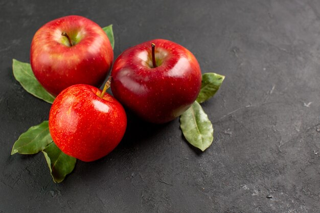 Vista frontal de las manzanas rojas frescas frutas suaves en la mesa oscura fruta roja fresca madura