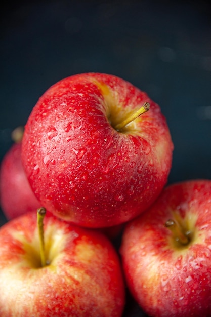 Vista frontal de manzanas rojas frescas sobre un fondo oscuro, árbol de color, vitamina madura suave, jugo de manzana, pera, dieta alimentaria