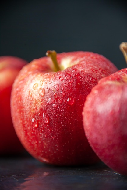 Vista frontal manzanas rojas frescas sobre fondo oscuro color suave vitamina madura manzana peral dieta alimentaria