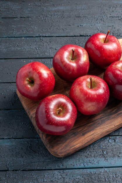 Vista frontal de las manzanas rojas frescas suaves frutos maduros en el escritorio de color azul oscuro de la fruta de color rojo vegetal vitamina fresca