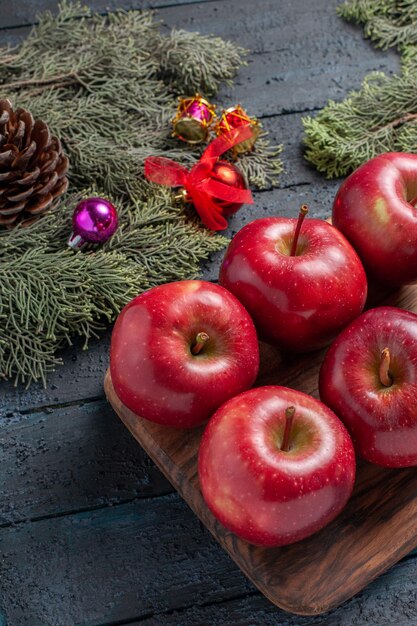 Vista frontal de las manzanas rojas frescas suaves frutos maduros en la planta de escritorio azul oscuro muchas frutas de color rojo vitamina fresca