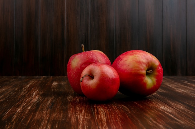 Vista frontal de manzanas rojas sobre un fondo de madera