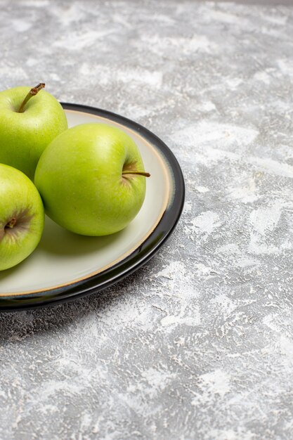 Vista frontal de las manzanas verdes frescas frutas suaves sobre la superficie blanca fruta fresca madura suave vitamina alimenticia