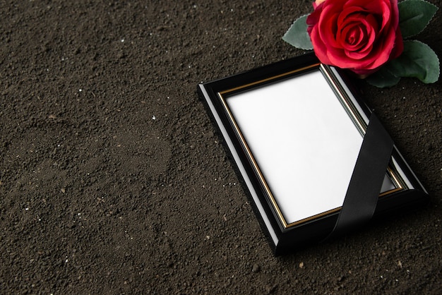 Vista frontal del marco de imagen con flor roja sobre el negro
