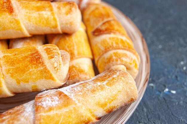 Vista frontal más cercana deliciosos brazaletes dulces con relleno dentro de la placa en el escritorio oscuro