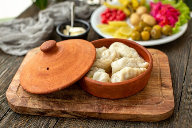 Una vista frontal de masa de carne con carne junto con verduras frescas en el escritorio rústico de madera marrón