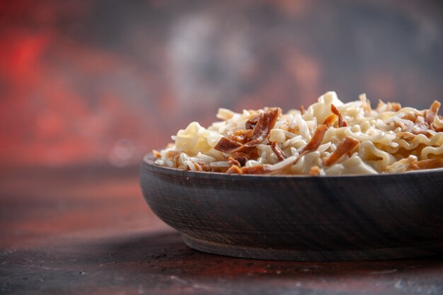 Vista frontal de masa cocida en rodajas con arroz sobre masa de plato de pasta de superficie oscura