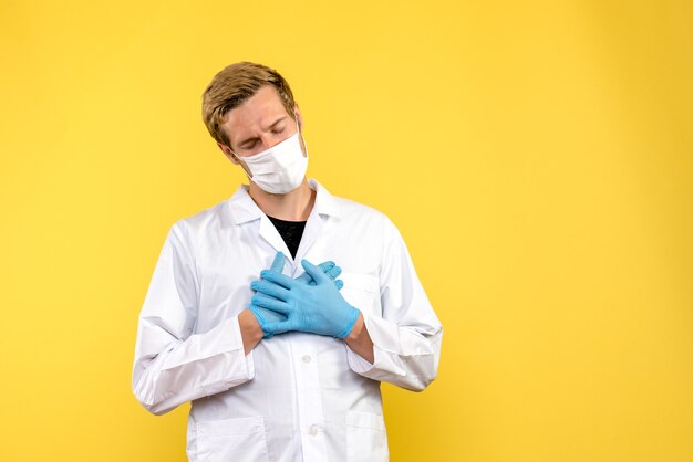 Vista frontal médico masculino sentirse cansado sobre fondo amarillo pandemia covid- virus de salud