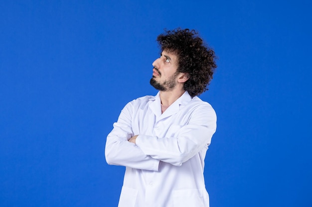 Vista frontal del médico masculino en traje médico sobre fondo azul medicina vacuna vacuna covid-virus pandemia salud coronavirus