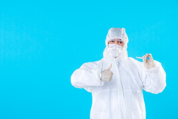 Vista frontal médico masculino en traje de protección con matraz en azul