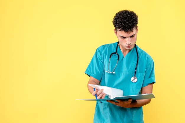 Vista frontal médico el médico con carpeta con documentos mira los resultados del paciente