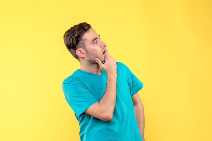 Foto gratuito vista frontal del médico de sexo masculino en la pared amarilla
