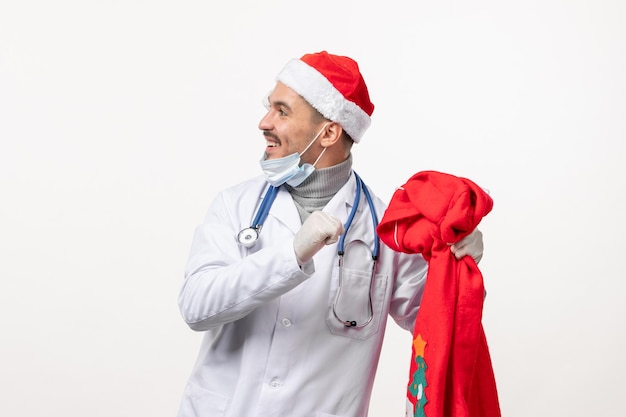 Vista frontal del médico varón con bolsa roja presente en la pared blanca