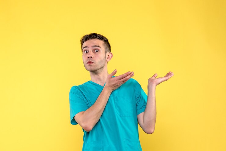 Foto gratuito vista frontal del médico varón con cara de sorpresa en la pared amarilla