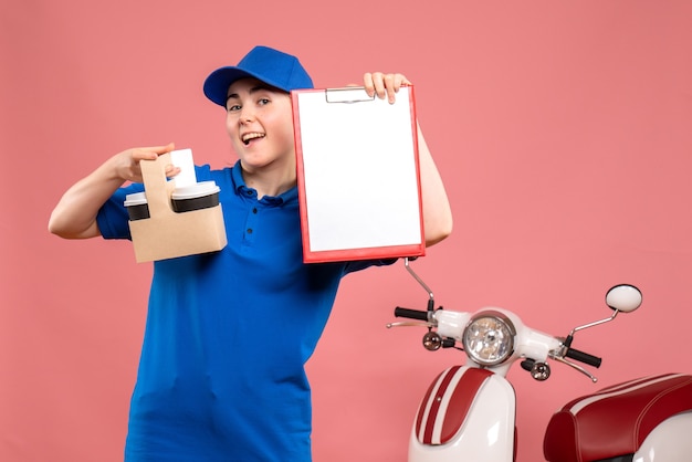 Vista frontal de mensajería femenina con café y nota de archivo sobre el servicio de uniforme de entrega de trabajo rosa trabajador de trabajo pizza mujer bicicleta