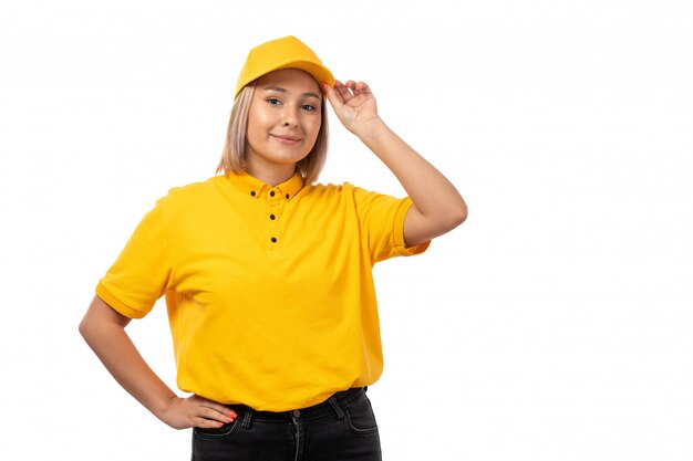 Una vista frontal de mensajería femenina en camisa amarilla gorra amarilla sonriendo en blanco