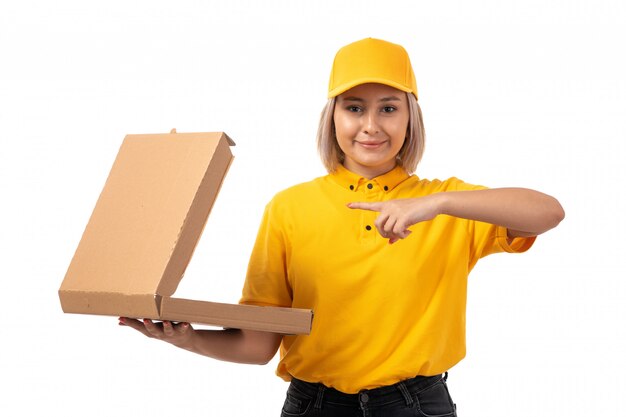 Una vista frontal de mensajería femenina en camisa amarilla gorra amarilla sonriendo sosteniendo cuadro en blanco