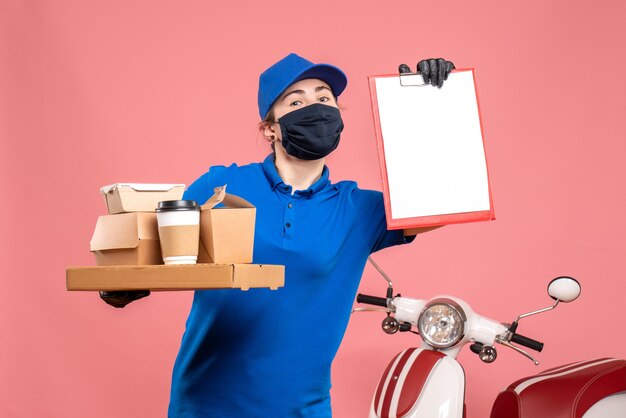 Vista frontal de mensajería femenina con entrega de café y comida en pandemia rosa trabajador del servicio de entrega de trabajo covid- trabajo uniforme