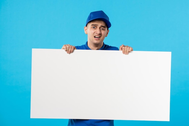 Vista frontal del mensajero masculino con escritorio blanco sobre azul