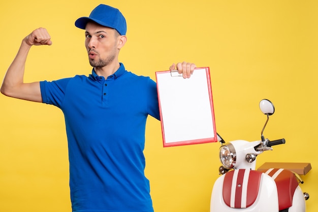 Vista frontal mensajero masculino sosteniendo nota de archivo en color amarillo trabajador uniforme bicicleta trabajo emoción