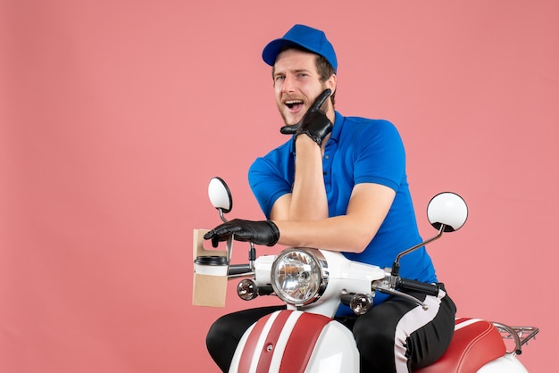 Vista frontal mensajero masculino en uniforme azul con café en el trabajo de color rosa servicio de entrega de comida rápida en bicicleta trabajo en color