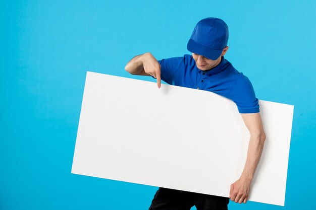 Vista frontal del mensajero masculino en uniforme con escritorio blanco azul