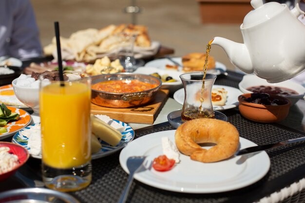 Una vista frontal de la mesa de desayuno personas alrededor de la mesa que comen durante el día comida desayuno té
