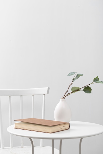 Vista frontal de la mesa con libro y jarrón