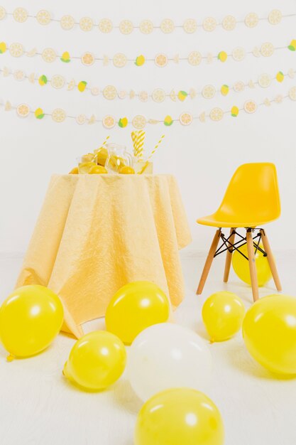Vista frontal de la mesa y silla con globos y limones