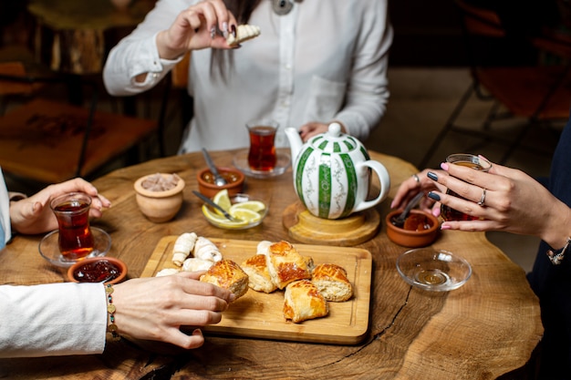 Una vista frontal de la mesa de té junto con pasteles y galletas