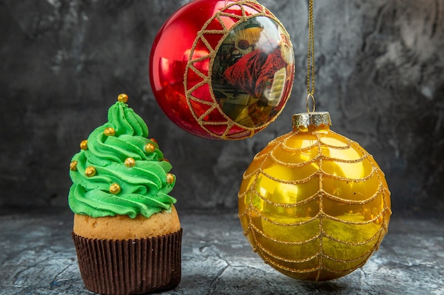 Vista frontal mini cupcakes coloridos bolas de árbol de navidad rojas y amarillas en navidad oscura