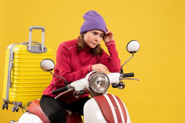 Vista frontal molesta a joven con sombrero morado en ciclomotor