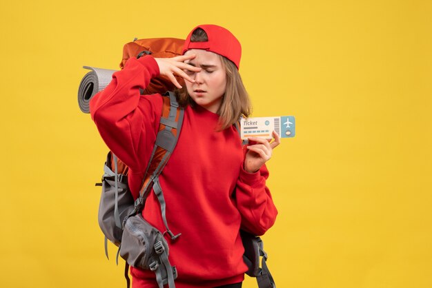 Vista frontal molesto mochilero mujer sosteniendo boleto aéreo