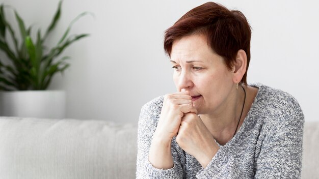 Vista frontal de la mujer con ansiedad en el sofá